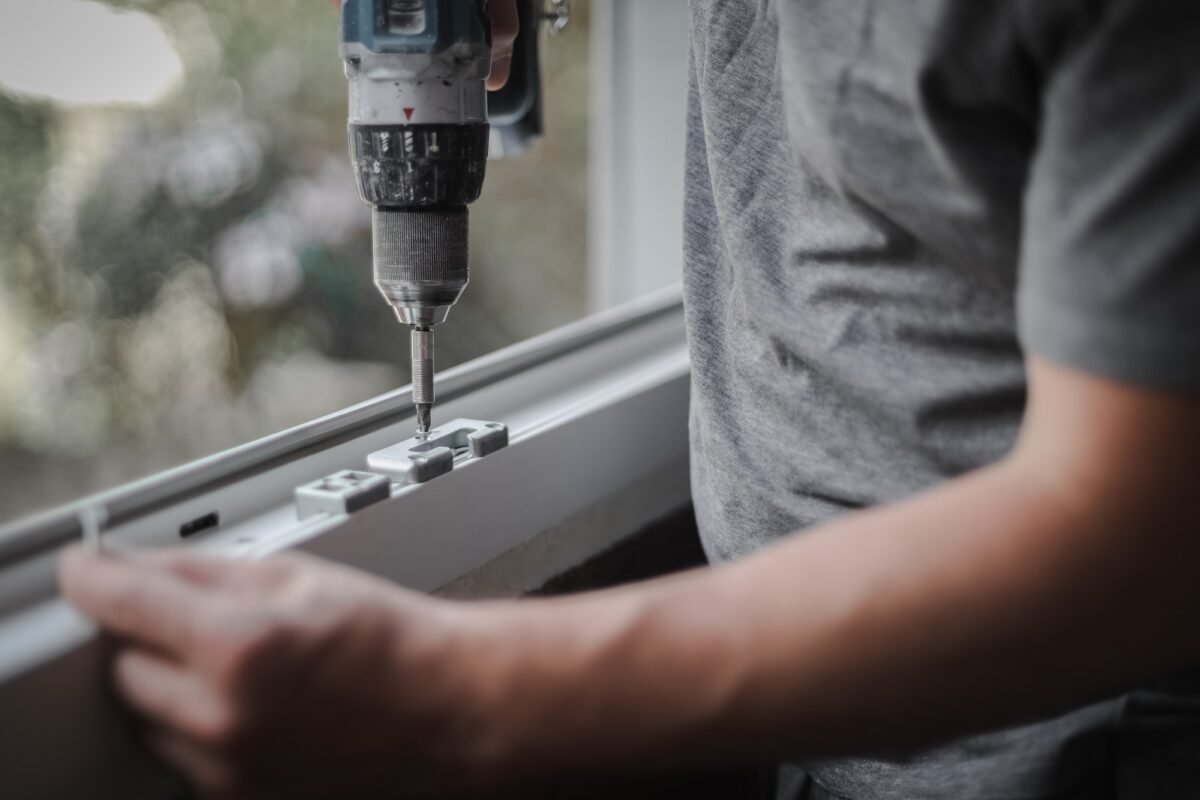 Caucasian man installs fittings for a window frame.